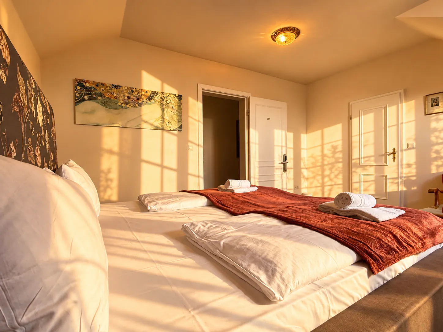 Bed with red throw, looking towards the door