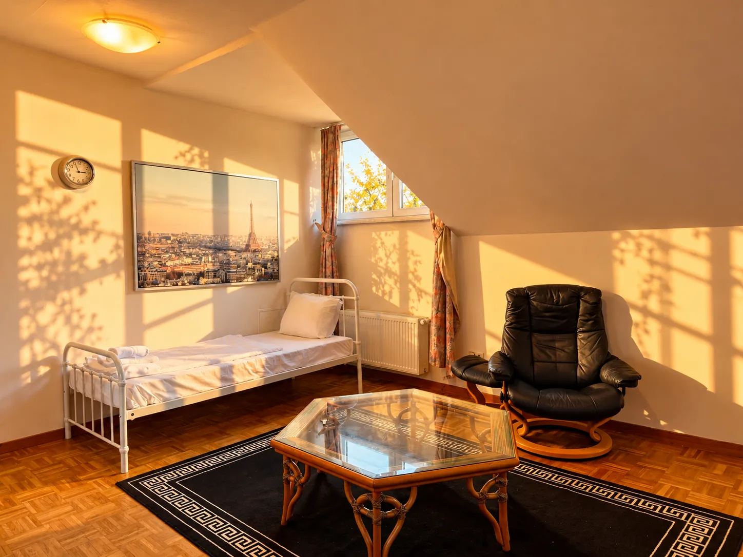 Attic room with single bed, armchair and coffee table